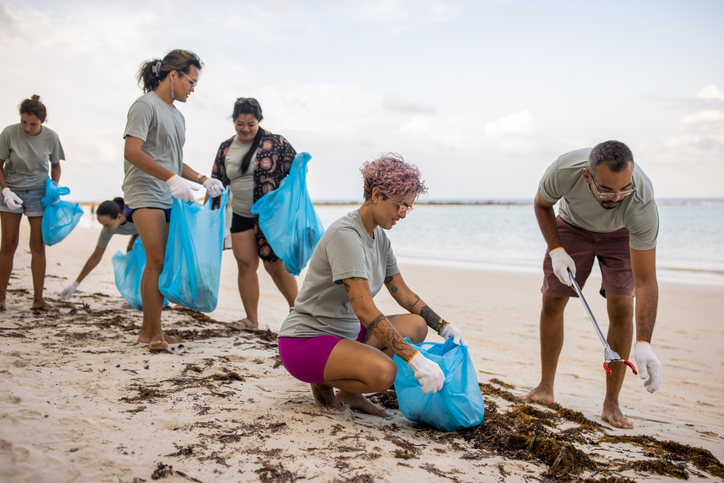 Clean Coast Crew volunteers seen on a beach in Texas picking up trash during a beach cleanup event